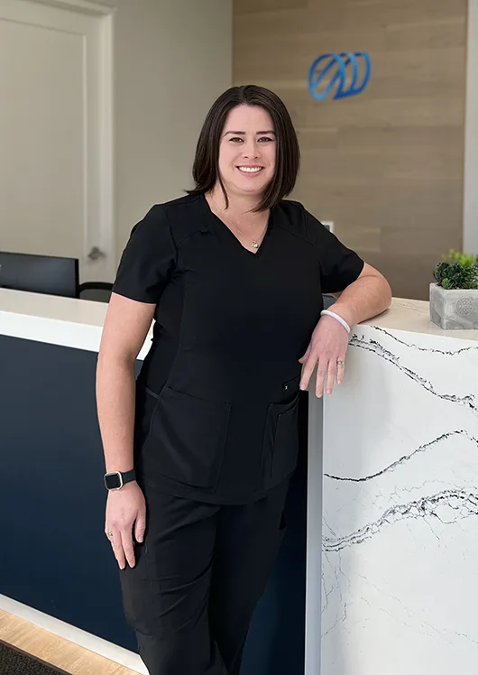 Female staff member leaning on clinic counter